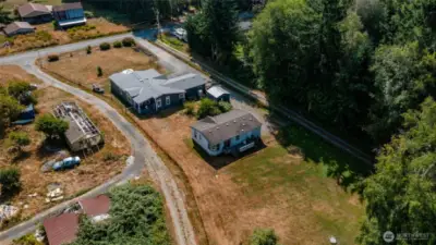 Aerial view of both homes. Fruit trees at back of property with grape vines in between the homes