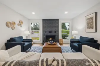 A bold accent fireplace anchors the living room with style and character, while the side windows wash the space in natural light. This combination creates a bright, cozy atmosphere that enhances the room’s open and welcoming feel.