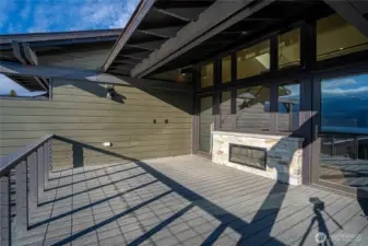 Indoor outdoor living with the fireplace and twin doors opening to the deck with two-side fireplace for indoor and outdoor enjoyment.