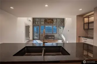 Striking solid slab marble kitchen counters and stylish gold fixtures are highlights in the kitchen with lake views always in sight.