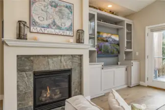 Beautiful gas fireplace is flanked by elegant custom built-ins that provide both style and ample storage space