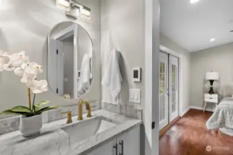 The ensuite bathroom is just as beautiful with quartz counters, modern light fixtures and gold hardware.