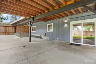 The expansive lower patio features a ramp with access to a gated entry to the side gravel parking area, perfect for unloading larger items to the backyard.