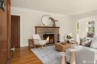 As you enter the home...Beautiful tiled wood burning fireplace, coved archways and walls of divided light windows flood this home with sunshine!