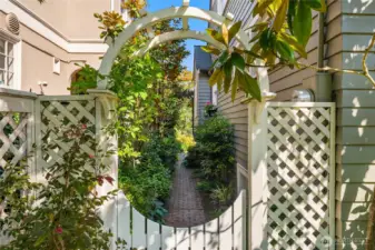 This gate is to the side of the front patio and via a charming brick pathway...leads to the back garden and the deck off of the kitchen.