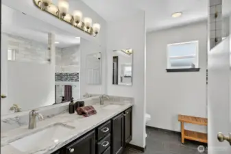Beautiful bathroom with tile, granite dual vanity and custom lighting.