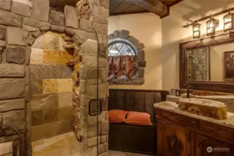 The Castle Suite amazes with its custom stone shower featuring a waterfall and rain shower head, antique vanity and rustic stone sink.