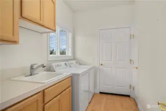 Main level laundry with utility sink & storage