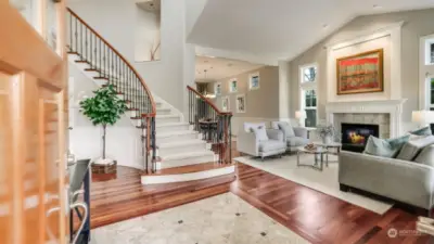 Gorgeous 2-story entry showcasing Brazilian cherry hardwood floors, marble tile inlay, and dramatic curved staircase.