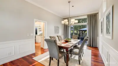 The dining room is accented by wainscot and crown molding details with French doors opening to newly added paver patio and pagoda-provides easy access to outdoor entertaining. 3 sunlit windows above.