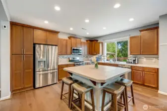 To the left of the refrigerator is a large panty cabinet. All appliances stay with the home. Layout allows for multiple cooks in the kitchen plus island eating.