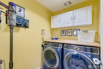 A utility room with cabinetry and folding counter.