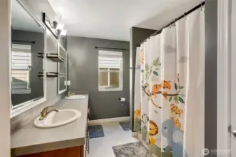 Hall full bathroom with double vanity and bathtub/shower.
