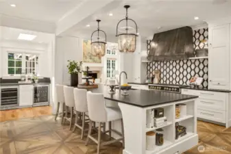 Spacious kitchen features top of the line cooking and refrigeration: 48” Big Chill range, separate wall oven and microwave, center island with sink, Subzero refrigerator, and beverage center with wine fridge
