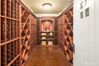 Temperature controlled wine cellar with arched door entry, cork floor and built-in wine racks