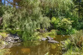 Lushly landscaped to complement the natural setting with sweeping flagstone terraces that overlook the waterfall and ponds