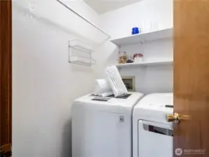 The laundry room is conveniently located by the kitchen and close to the garage exit.