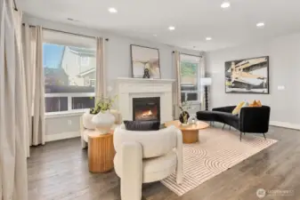 Living room featuring built-in speakers, tinting on windows, and gas fireplace.