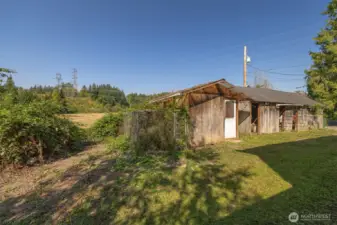 Old outbuilding with field to the north behind it.