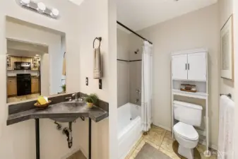 Main floor full bathroom with built in storage and concrete counters
