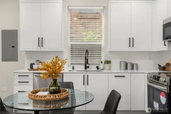 Bright and functional kitchen with quartz countertops, stainless appliances, and seamless flow to dining and living areas.