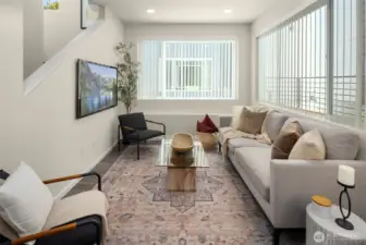 Sun-soaked living room with tall ceilings and oversized windows — every day feels a little more elevated.