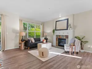 Spacious living room with new LVP flooring and gas fireplace.