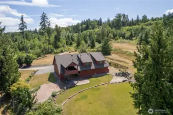 Mature landscaping and natural forest create a picturesque backdrop for the property's generous outdoor entertaining spaces, ideal for elegant hosting or tranquil retreat. Sprinkler system and drip system for landscaping and grass.