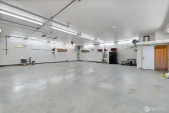 The expansive 40' x 42' shop, located beneath the living space, is a dream for hobbyists and professionals alike. It includes a 3/4 bathroom with a shower, a powerful 5 HP Quincy air compressor, and an oversized 150,000 BTU propane heater. A 4" exhaust port is built into the wall—ideal for woodworking or use with a blast cabinet. The custom concrete slab is built to last, featuring 23 chain pots, heavy reinforcement with Sch. 40 half-inch rebar spaced 2 feet on center and epoxied into the footing, Propex semi-industrial fibers, and a six-sack mix poured to a 6-inch thickness, plus R38 Insulation in garage/shop ceiling.
