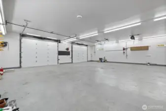 The shop is equipped with 200-amp electrical service and two oversized 12' wide by 10' high garage doors for easy access. Extra lighting is installed throughout to ensure a bright, functional workspace. With 23 heavy-duty chain pots integrated into the slab, the space is ideal for auto body work, securing large equipment, or tackling serious fabrication projects.