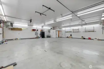 Piping has been installed throughout the shop to support the air compressor system, ensuring efficient air distribution. To the left, the 150,000 BTU propane heater keeps the workspace warm year-round. In the back right corner, you'll find a bathroom with a shower. An additional entrance door, to the right of the bathroom door, offers convenient access to the carport. This versatile space is designed for function and flexibility—offering endless possibilities for work, storage, or creative projects.