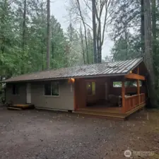 Exterior with outdoor living deck extension.  All cedar 325 sf trex deck.  Year around grilling is easy here.  Home on rare single driveway has great privacy.