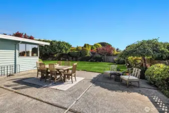Big open patio space with flat level backyard and grass.
