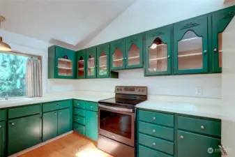 Freshly painted cabinets, glass cabinet fronts,  vaulted ceiling with skylight make for a bright welcoming kitchen.