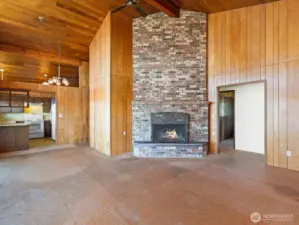 Opening to entry hall is to the right, fireplace center, dining and kitchen to the left