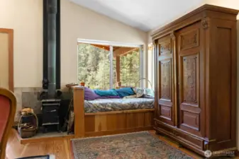The corner daybed is designed to hold firewood that can be loaded from outside, or use it for storage of other items. The wood-stove, though small, is plenty sufficient to keep this well-insulated cabin warm through the winter.