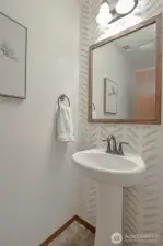 The half bathroom on the first floor includes a stylish pedestal sink, adding a touch of elegance to the space.