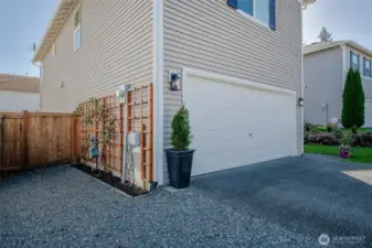 The property includes a gravel area for extra parking and a side gate for easy backyard access—plus, enjoy the charm of decorative climbing plants along the side yard!