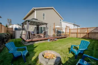 Step into the backyard from the kitchen through a sliding glass door that opens to a spacious deck with a cozy gazebo seating area. Enjoy entertaining around the fire pit, tending to raised garden beds, and storing tools with ease in the large shed—everything you need for outdoor living! The gazebo stays with the home!