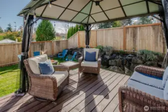 The gazebo on the deck provides a comfortable, shaded seating area just steps from the fire pit—perfect for gathering with friends and enjoying the backyard ambiance.