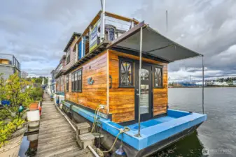 As you walk down the dock to this Seattle houseboat 28' X 10' dimensions with a rooftop deck overlooking the Ship Canal  you will see why this lifestyle is so important to your soul.