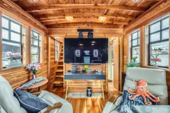 Walls of windows with lake and canal views wvwrywhere.  Viwe from the kitchen into the living room and to the right is the 3/4 bath. To the left you will LOVE the Pantry/Storage room, then up the stairs leads to the buil-in queen sized bedroom and lots of built-in storage space.