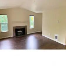 Vaulted living room with a slate wood burning fire place and a slider to the deck.
