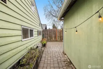 Walk way to the fenced in patio between the home (left) and garage (right)