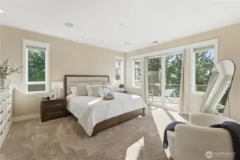 A serene primary bedroom with walk-out deck access showcases never-ending views and spectacular sunsets. The suite continues with a full bathroom, oversized laundry room, generous walk-in closet, and an office