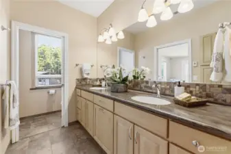 A well-appointed second primary bathroom with dual sinks, warm heated floors, a private toilet room, and a generous shower just to the right