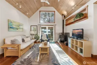 Cottage #1 features vaulted ceilings, a separate main bedroom, and an upstairs loft with a twin bedroom. The full bathroom sits just off the bathroom.  The main living overlooks the calm bay beyond the outdoor kitchen and deck