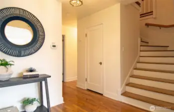 Gleaming oak hardwoods in entryway, spacious cedar coat/storage closet to left of stairs