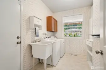 Laundry room off the garage with plenty of storage and sink