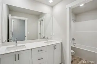 Guest bathroom with tub and quartz counters
